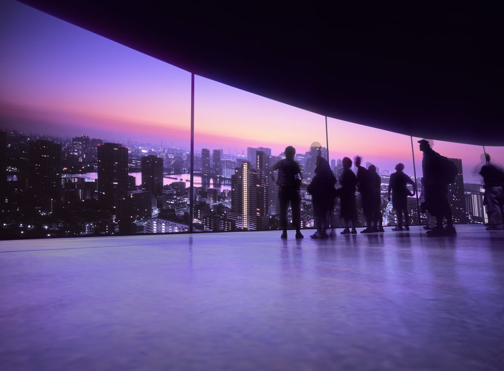 silhouette of people looking at a city skyline through a glass window - high resolution