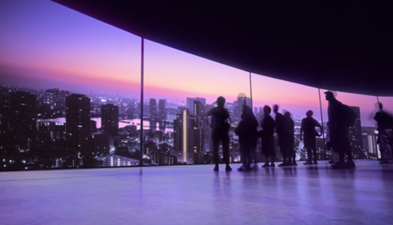 silhouette of people looking at a city skyline through a glass window